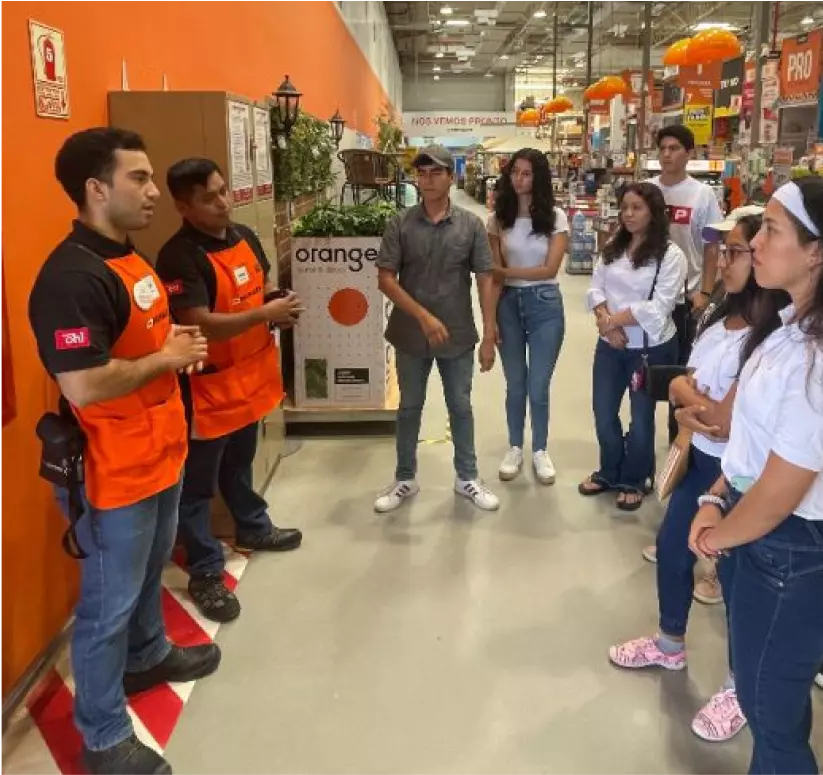 Jefe de tienda de Promart explicando operaciones a alumnos